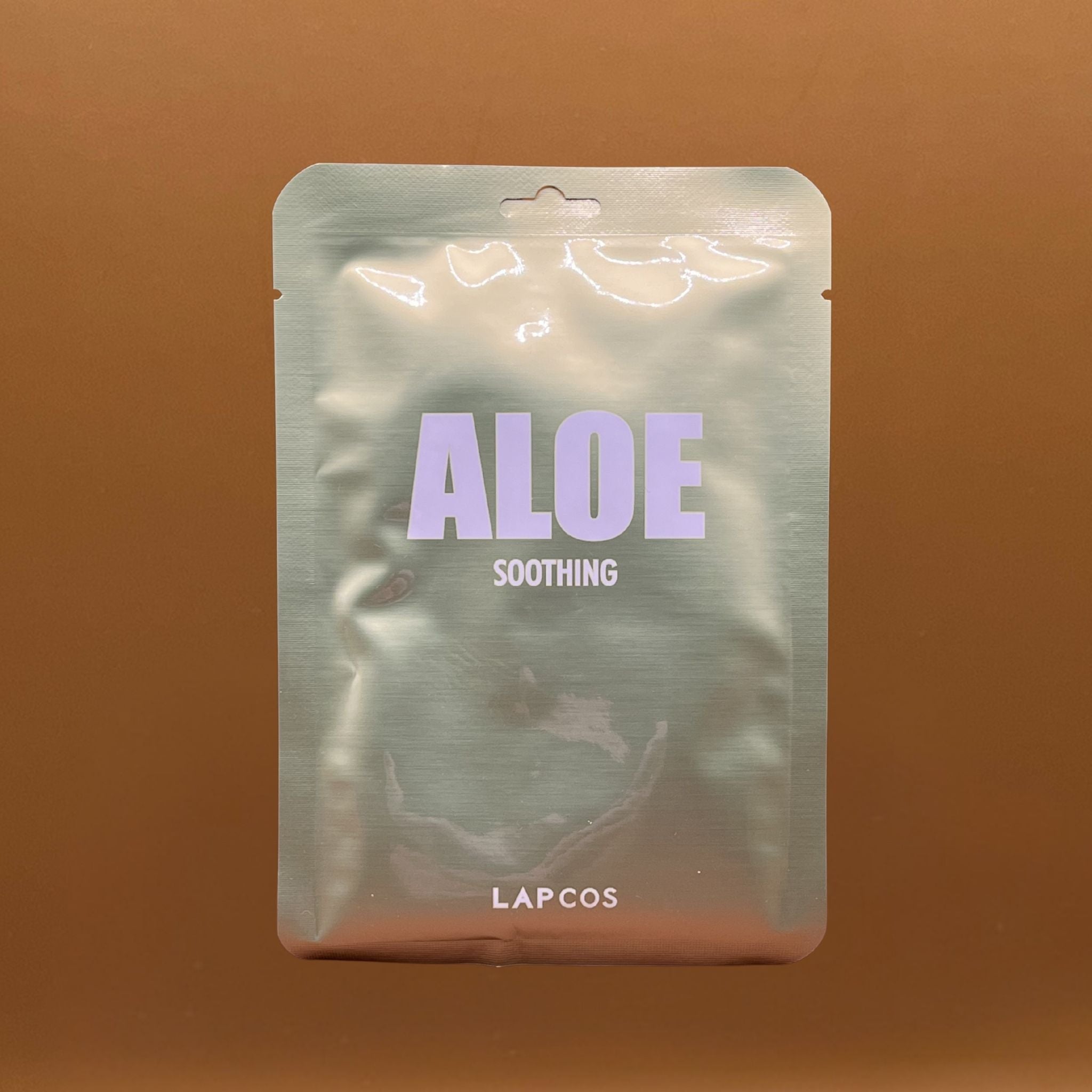 Lapcos aloe soothing product packaging on a brown background