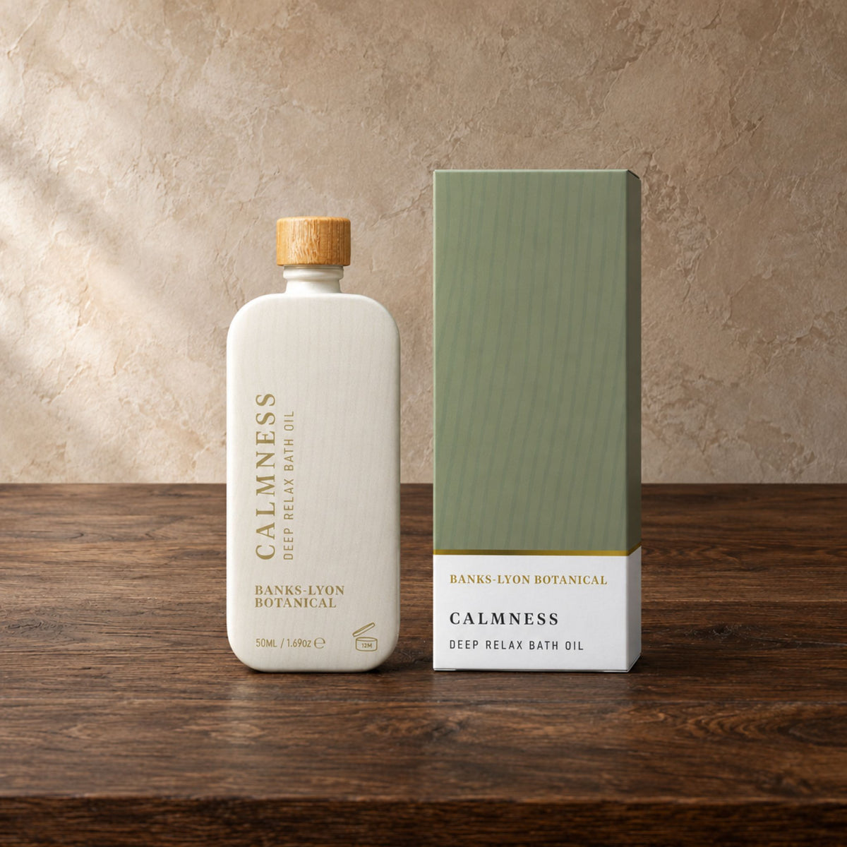 A bottle of Banks Lyon Botanical Calmness Deep Relax Bath Oil stands next to its matching green and white box on a dark wooden surface against a textured beige wall.