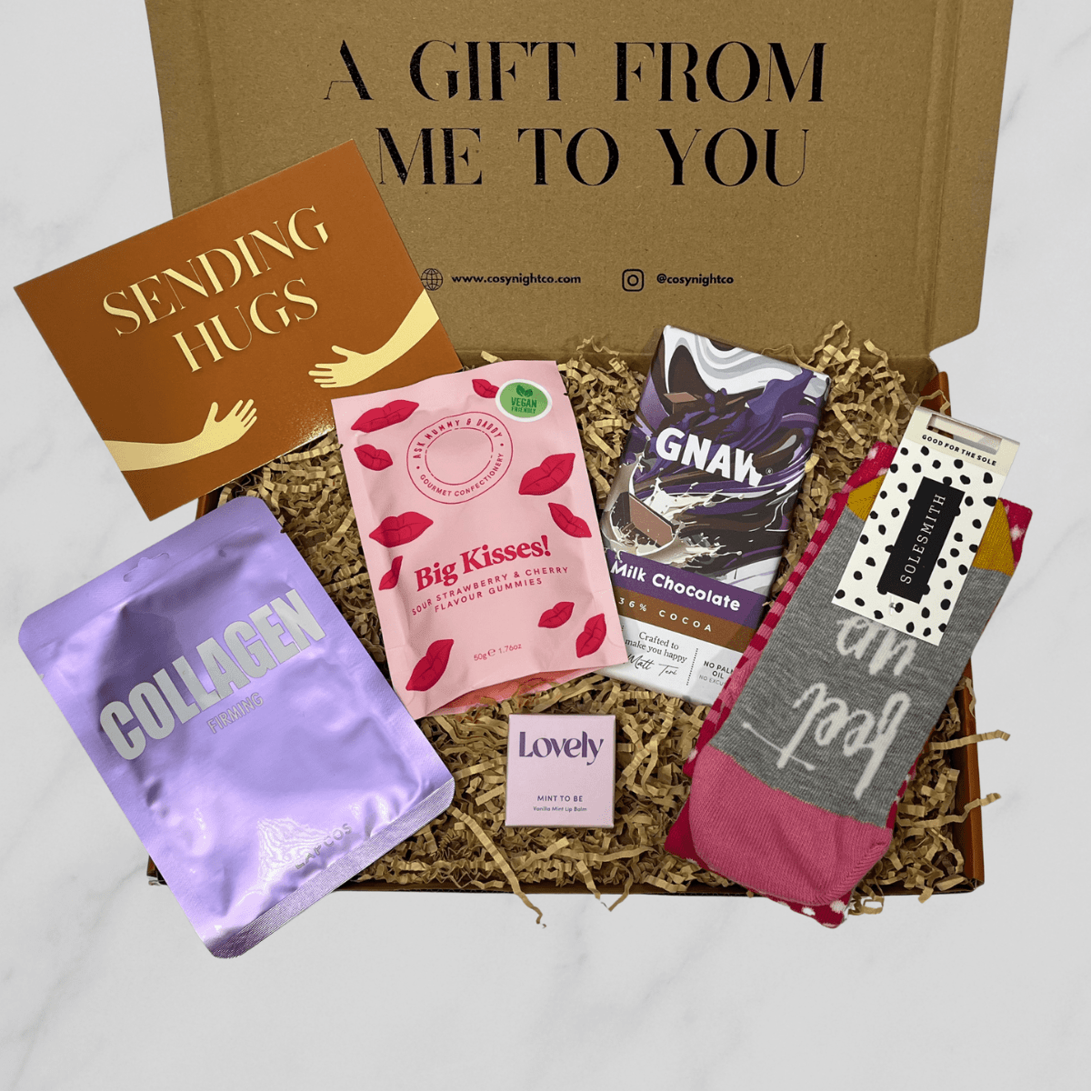 Self Care letterbox gift box with cosy socks, chocolate bar, gummies, face mask and lip balm.