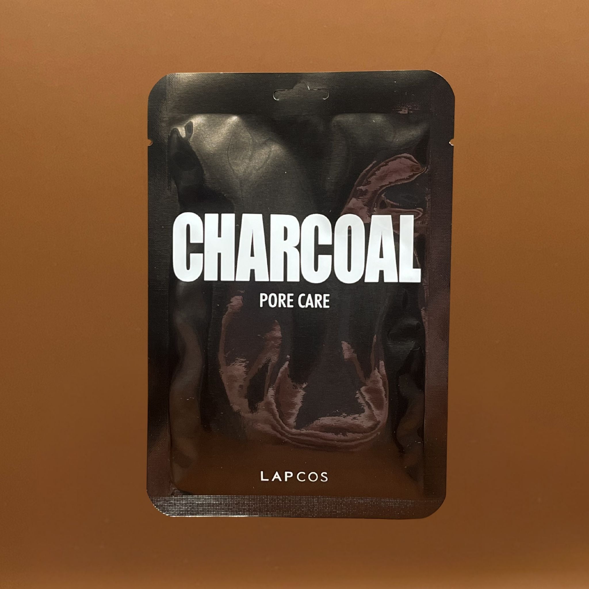 LAPCOS charcoal pore care product packaging on a brown background