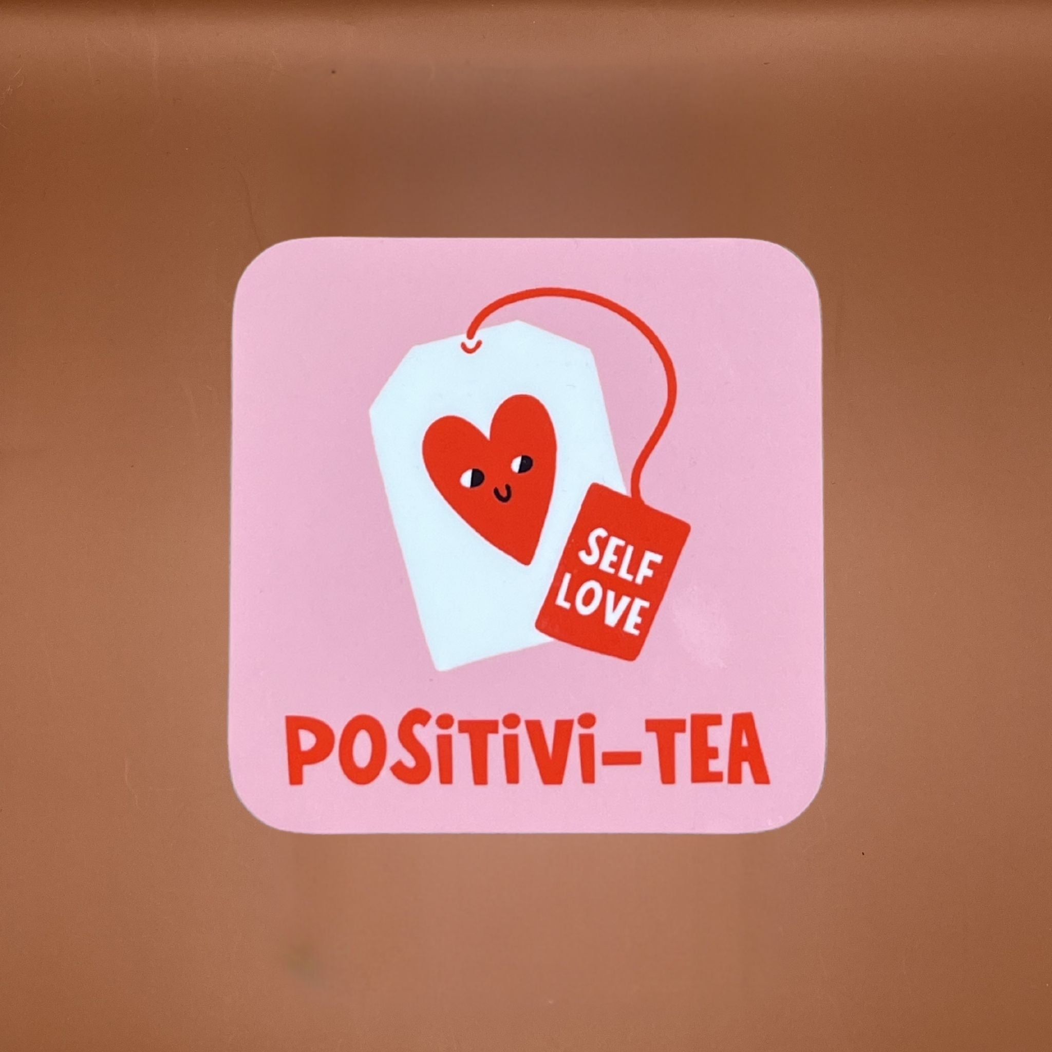 Coaster with 'Positivi-Tea' design on a pink background