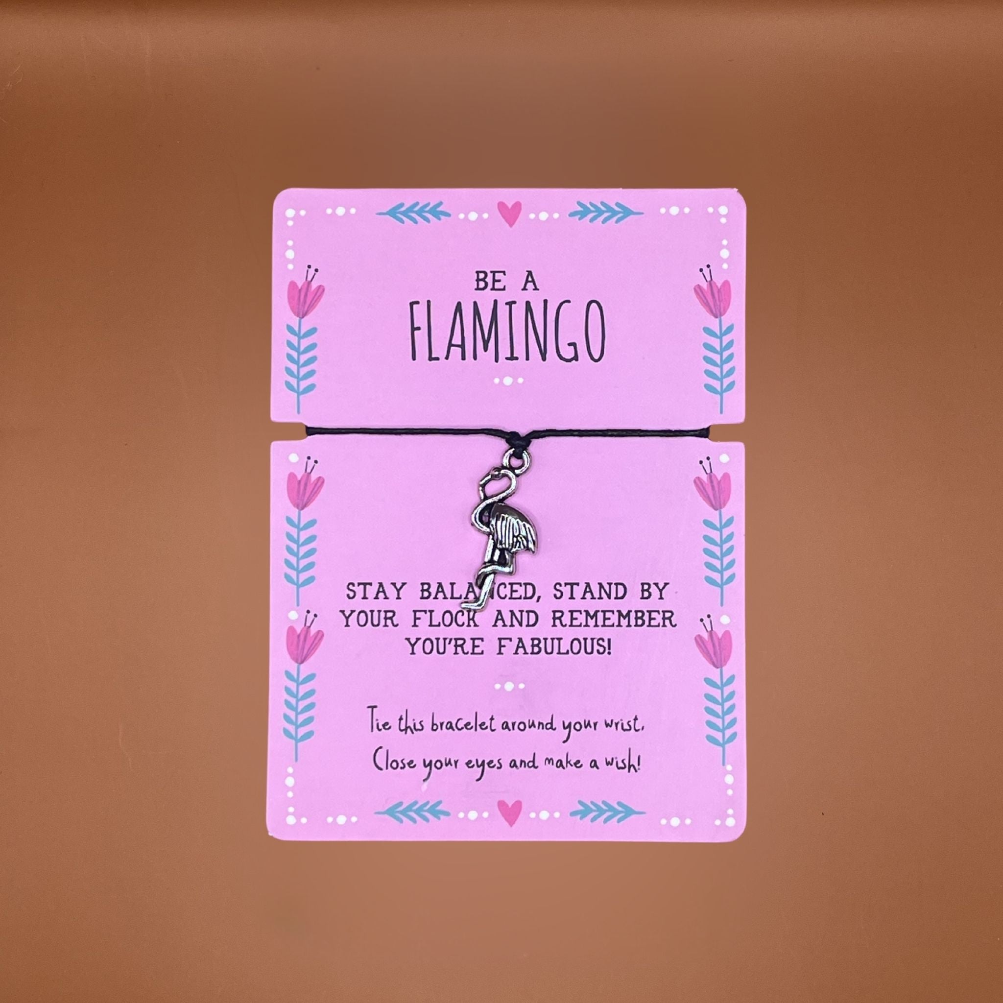 Bracelet with flamingo charm on pink card with a friendly message on