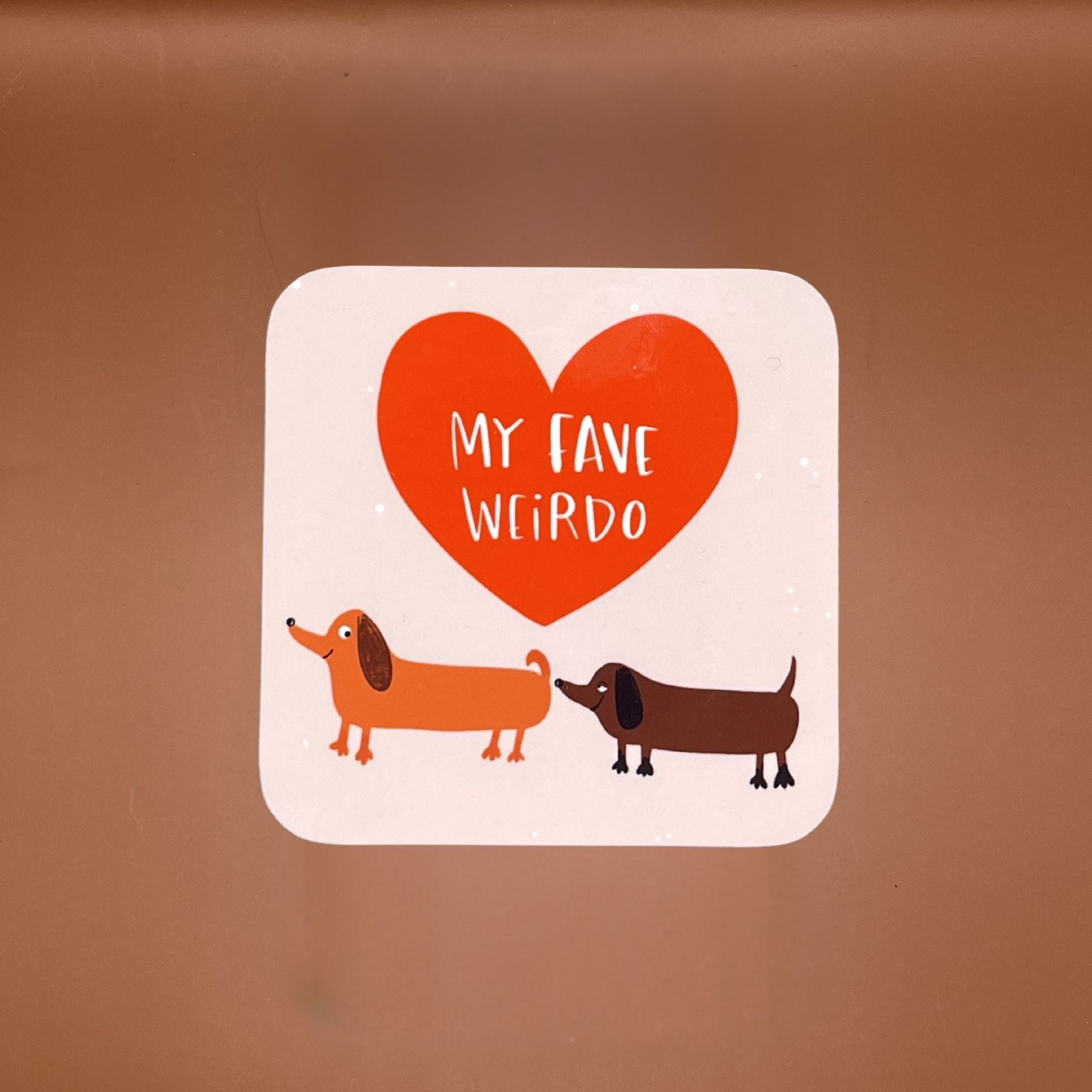 Coaster with two dachshunds and a heart that says 'My Fave Weirdo'.