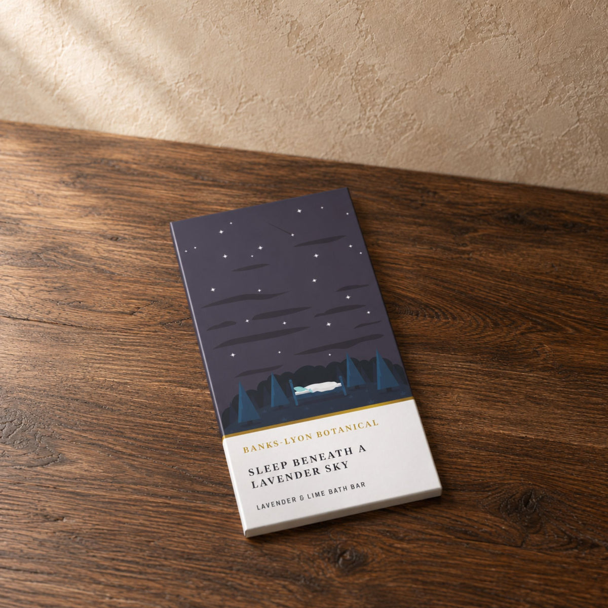A lavender and lime bath bar with a starry night design on the packaging placed on a dark oak table.