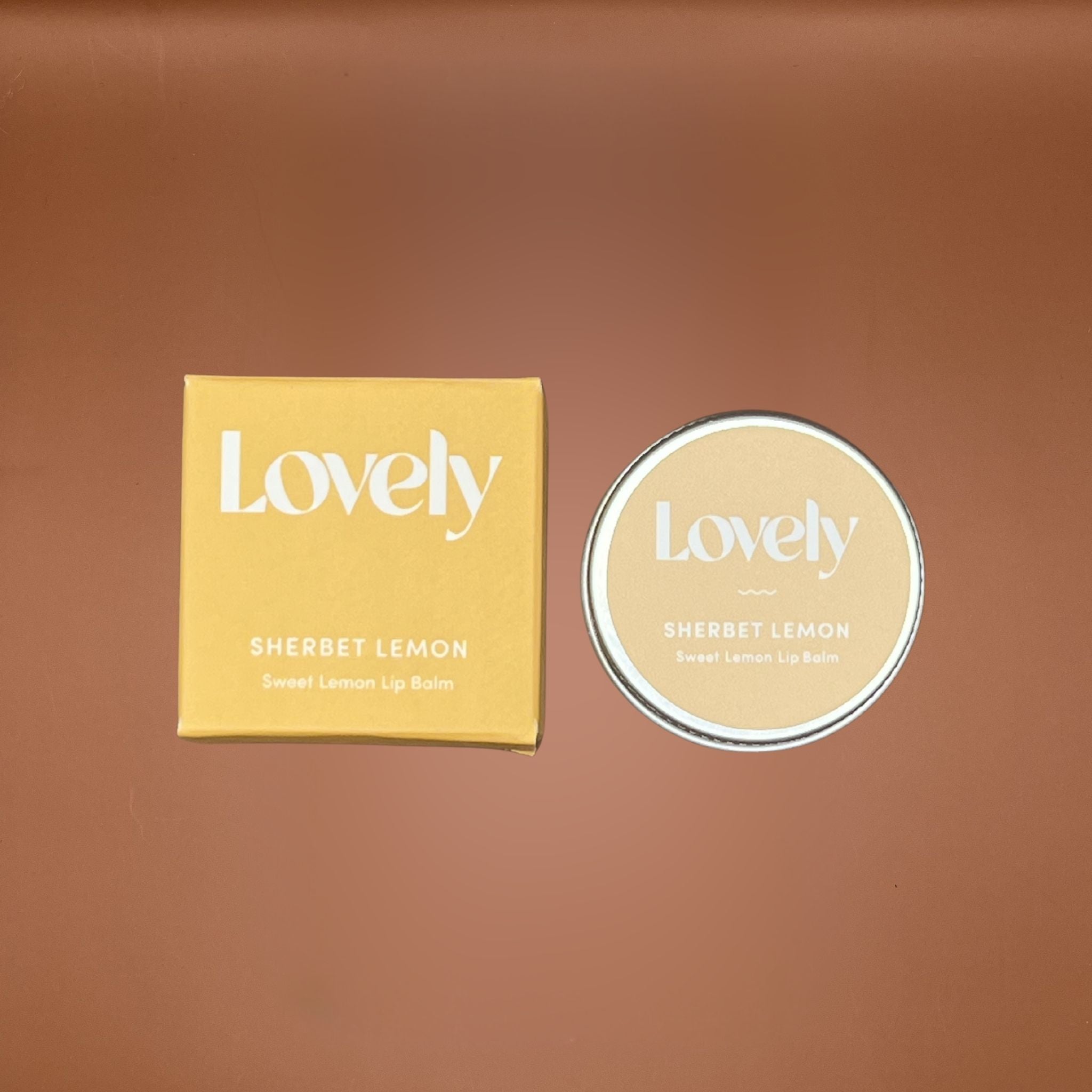 Sherbet Lemon lip balm packaging with 'Lovely' branding on a brown background