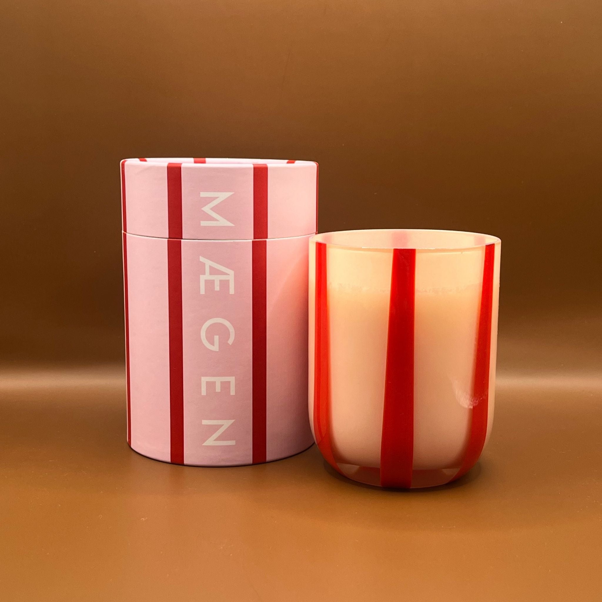 Pink striped container and candle in pink striped glass vessel with Maegen branding