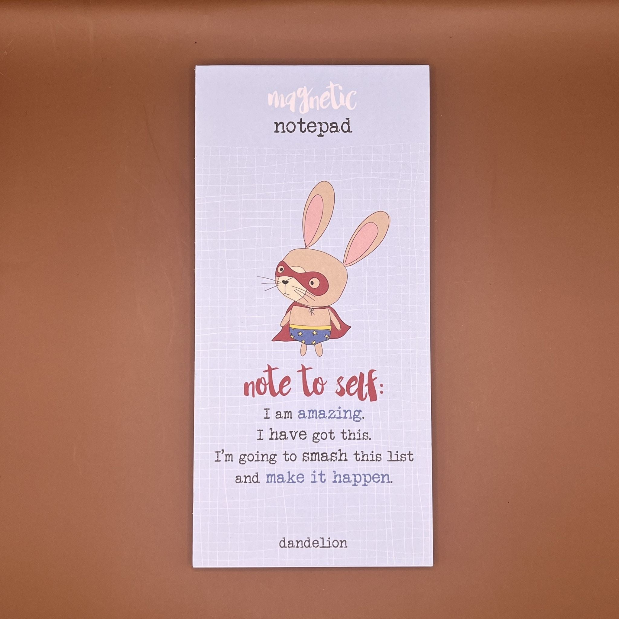 Notepad with superhero rabbit illustration and motivational text