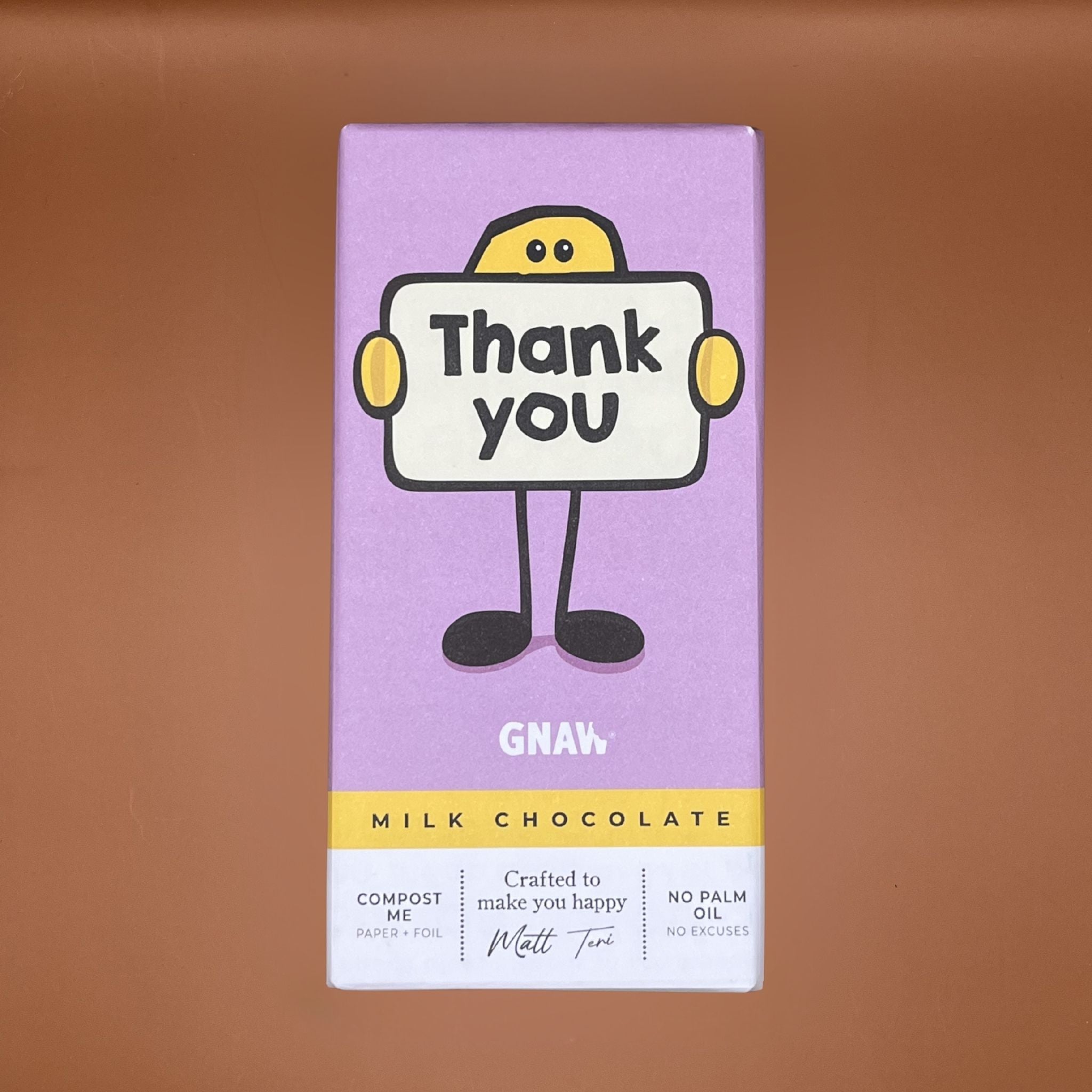 Milk chocolate bar with a cartoon character holding a 'Thank you' sign on a brown background