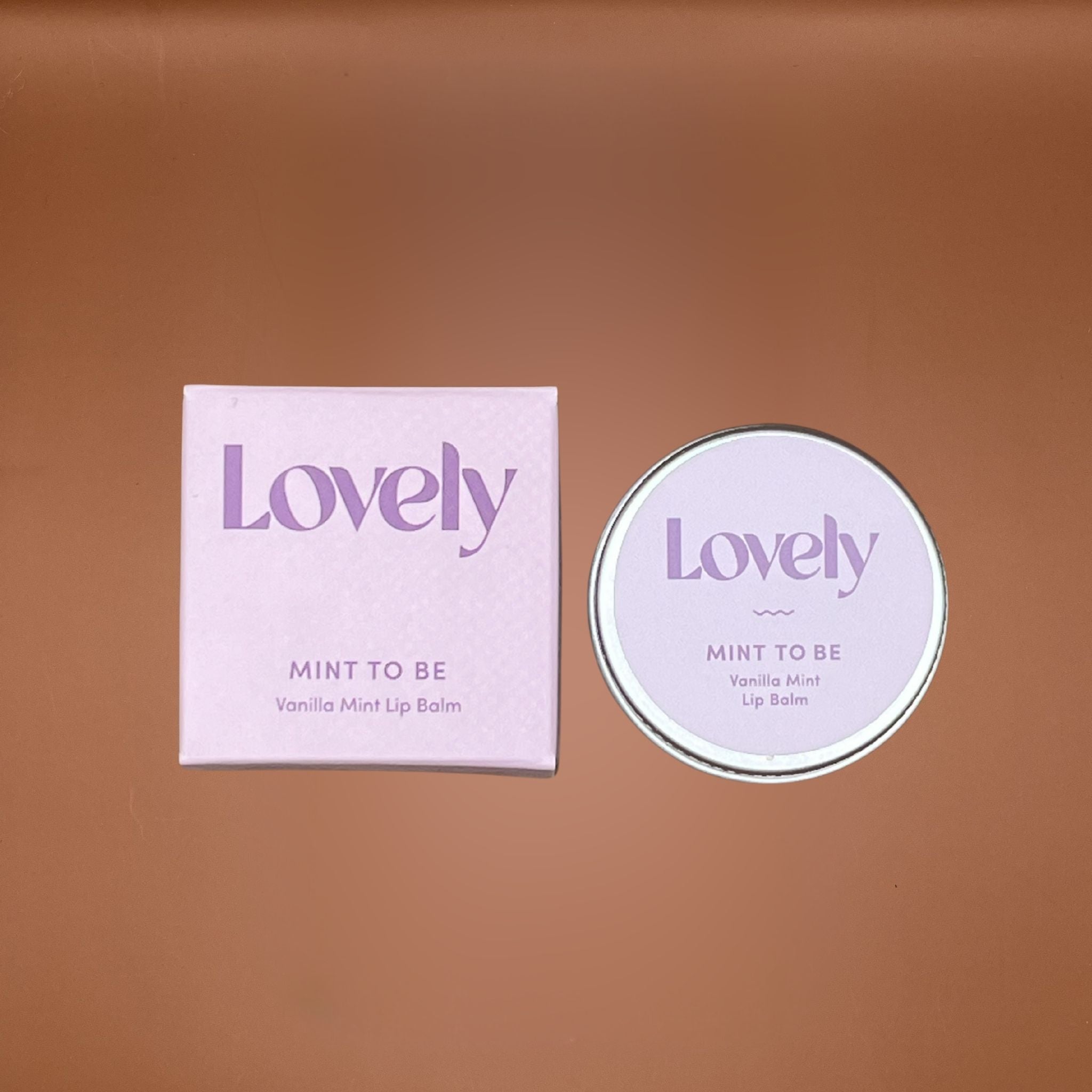 Lovely Mint to Be lip balm packaging on a brown background
