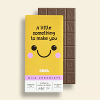 Chocolate bar with a yellow packaging featuring a smiley face and text on a beige background