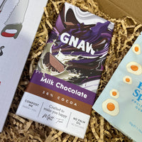 Gnaw Milk Chocolate bar with 36% cocoa, featuring bold purple packaging and eco-friendly compostable wrapping.