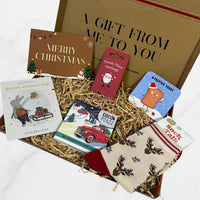 Christmas letterbox gift box containing festive reindeer socks, candy cane earrings, chocolate bar, wish bracelet, coaster, and Merry Christmas message card.