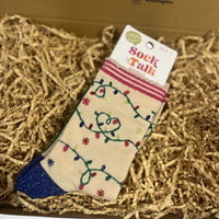 Pair of Sock Talk bamboo Christmas socks featuring a cream background with colourful festive light designs and glittery blue toes.