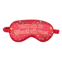 Red sleep mask with 'Wake Me Up When It's Christmas' text and Christmas design.
