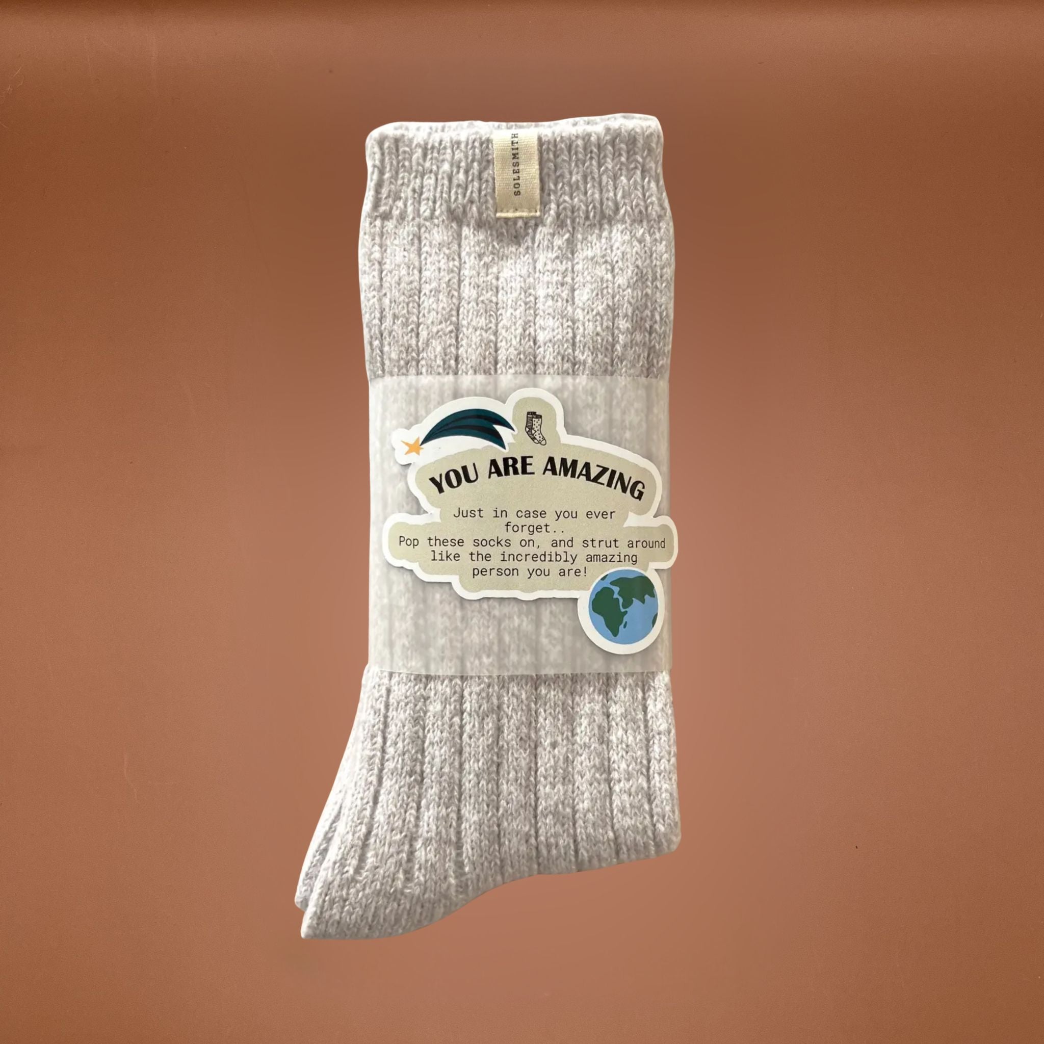 Grey sock with a gift message label on a brown background