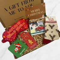 Christmas letterbox gift box featuring festive socks, a red sleep mask, chocolate bar, Santa coaster, gingerbread keyring, and Christmas card.
