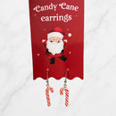 Festive red and white candy cane earrings displayed on a red backing card featuring a cheerful Santa illustration.