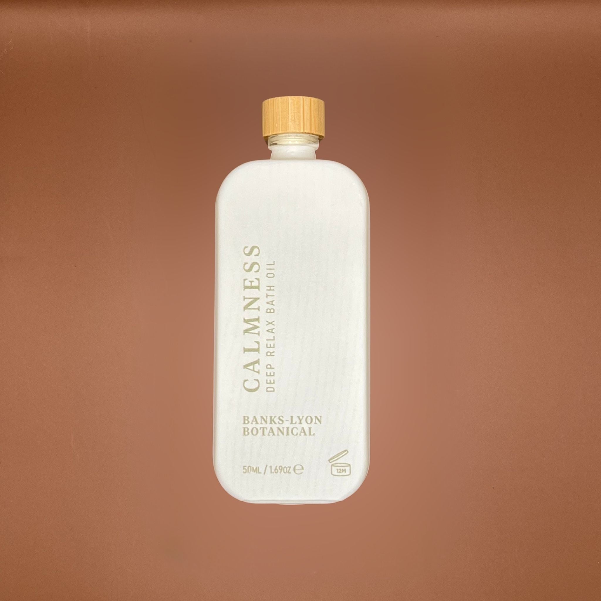 Bottle of Calmness deep relax bath oil in a white glass bottle with a wooden cap