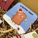 Christmas coaster with a funny festive toast design wearing a Santa hat and holding a drink in the snow.
