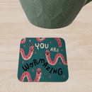 Funny celebration themed coaster featuring worms with party hats on a green background.