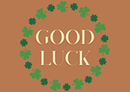 Good Luck text surrounded by green clover leaves on a brown background