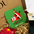 Green Christmas coaster featuring a playful illustration of Santa doing a handstand while holding a wrapped Christmas present.