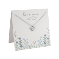 Silver Highland cow necklace displayed on a floral card with the message “Love you ’til the cows come home.”