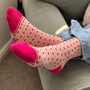 Cosy heart pattern socks with pink toes and heels worn while relaxing at home.