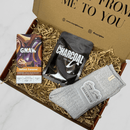 Letterbox gift box with luxury grey socks, salted caramel chocolate bar and charcoal face mask.