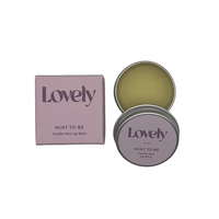 Purple Lovely Skincare mint to be box next to open tin of vanilla mint lip balm.
