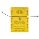 Bracelet with pineapple charm on a yellow card with text