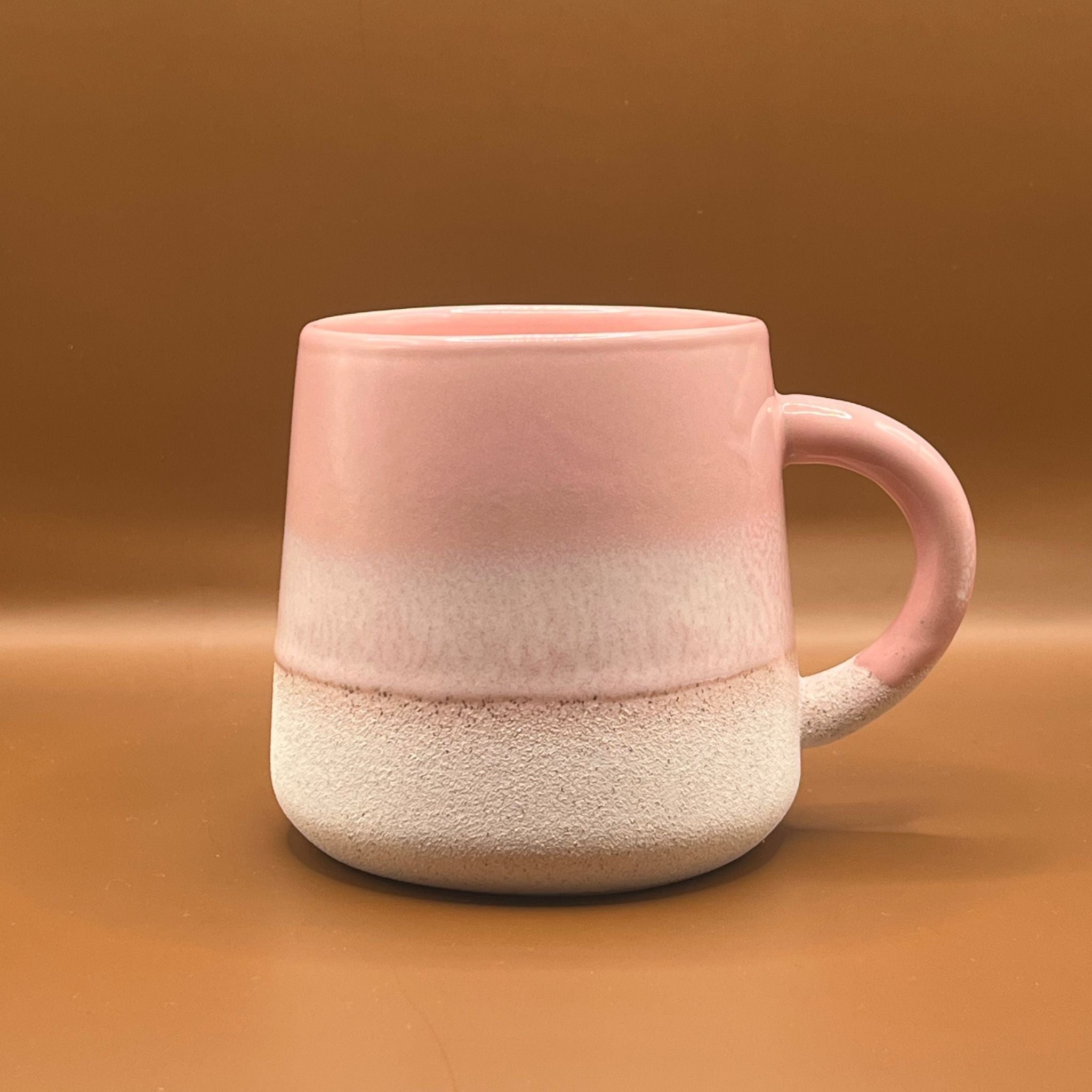 Stoneware mug with glossy pink top half and a white stoneware finish on the bottom half