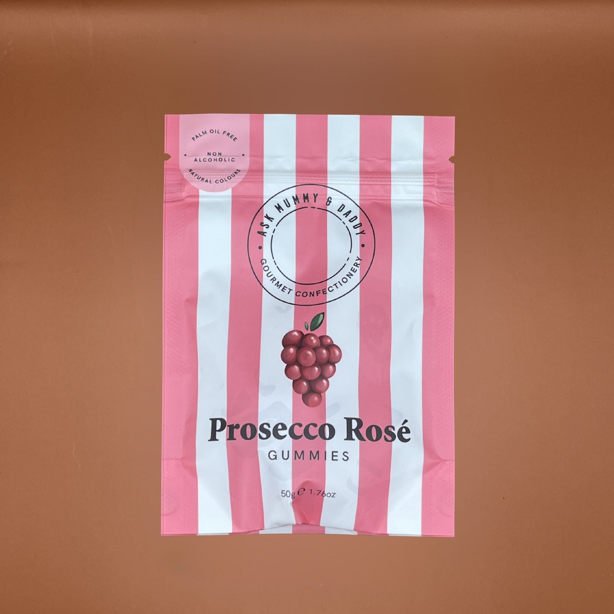 Pink and white striped packaging of Prosecco Rosé gummies on a brown background