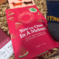 Close-up of You’re One In A Melon sour watermelon gummies inside letterbox gift box.