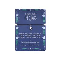 Bracelet with star charm on a blue card with motivational text saying reach for the stars.